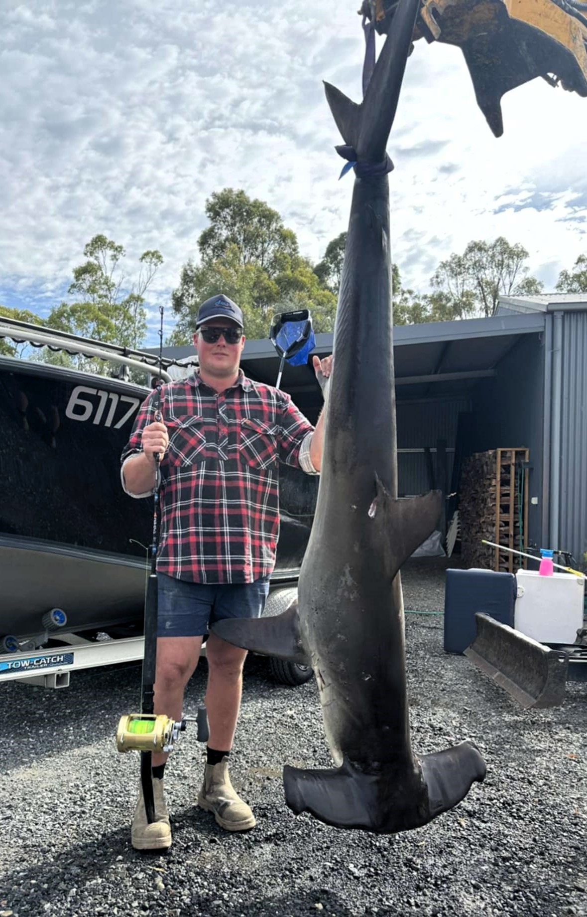 Daniel Hinds with the 114.3 kg hammerhead shark he caught with mates Jed Sutherland and Jordy Reitsema off Bridport last weekend.