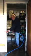 One man clean up crew Brian at New Norfolk Bowls Club indicates how high the flood waters reached